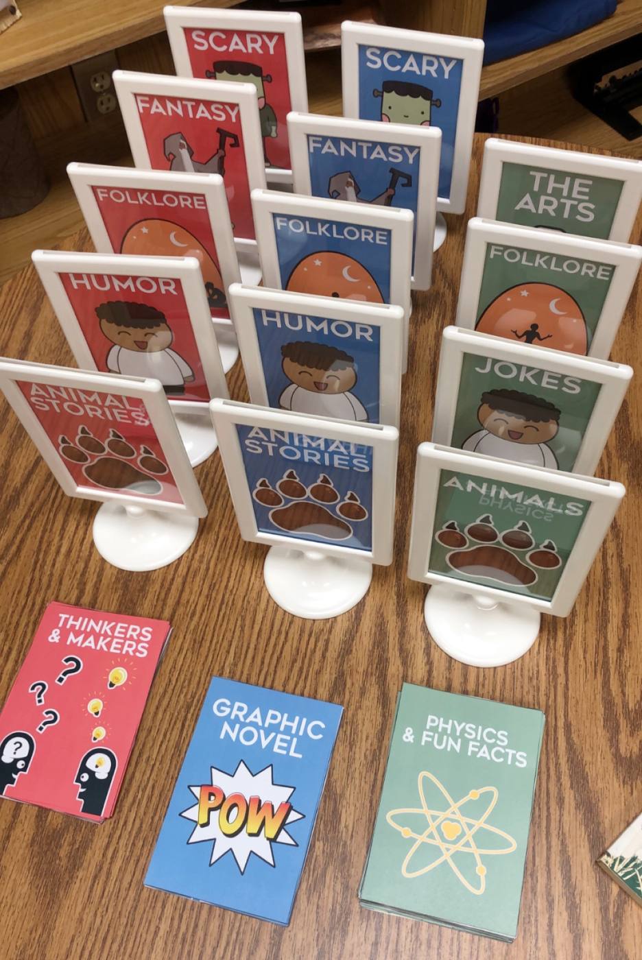 Rows of framed genre signs lined up on a table, ready to be placed.